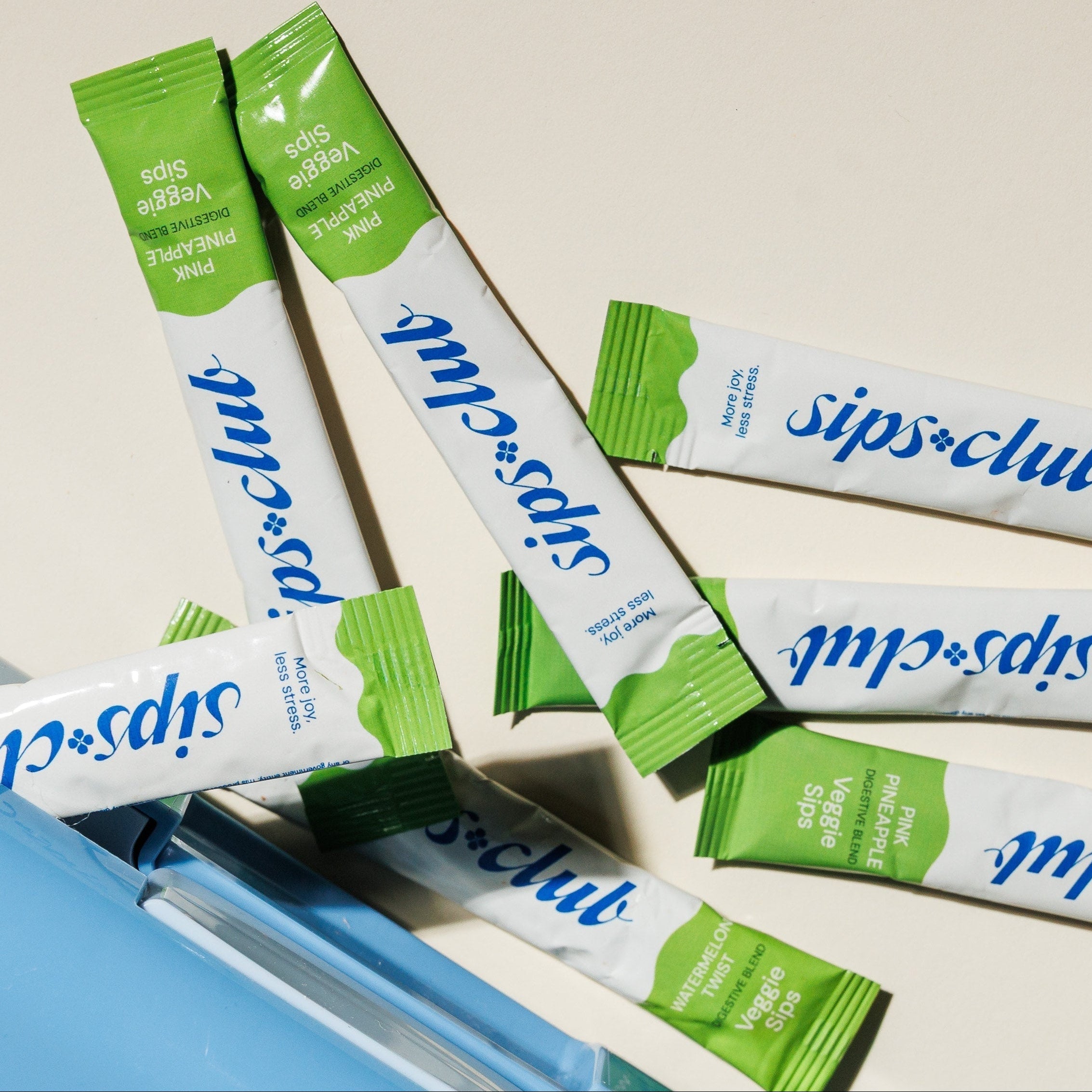 Sips-clut packets with a blue container featuring dinosaur illustrations on a beige background